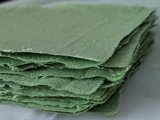 Stack of green paper towels on a white surface